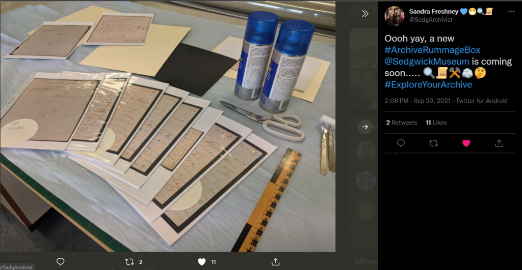A tweet showing a new rummage box being created. In the photo there are facsimiles of documents in protective films spread across a table, a ruler, scissors and spray cans of glue.
